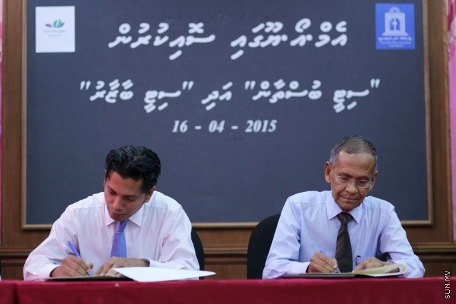 އޭޕްރީލް 16، 2015: ދަނޑުވެރި ކަމާއި ކުދި ވިޔަފާރިތައް ކުރުމަށް އާންމުނަށް އެހީތެރިކަން ފޯރުކޮށްދިނުމުގެ ގޮތުން މޯލްޑިވްސް ނޭޝަނަލް ޔުނިވާސިޓީ (އެމްއެންޔޫ) އާއި އައްޑޫ ސިޓީ ކައުންސިލާ ދެމެދެ އެއްބަސްވުމެއްގައި ސޮއިކުރުމަށް ބޭއްވުނު ރަސްމިއްޔާތުގެ ތެރެެއިން -- ސަން ފޮޓޯ/ ފަޔާޒު މޫސާ
