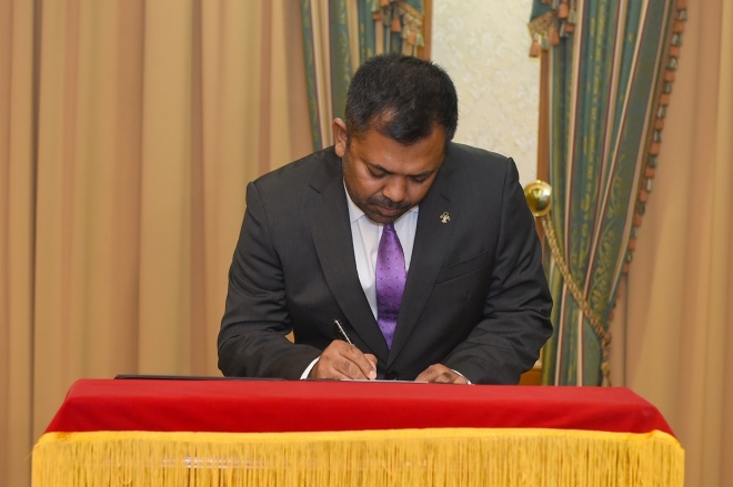 ޓޫރިޒަމް މިނިސްޓަރު ކަމަށް އައްޔަން ކުރެއްވި މޫސާ ޒަމީރު މަގާމުގެ ލިޔުމުގައި ސޮއިކުރައްވަނީ -- ފޮޓޯ: ރައީސް އޮފީސް