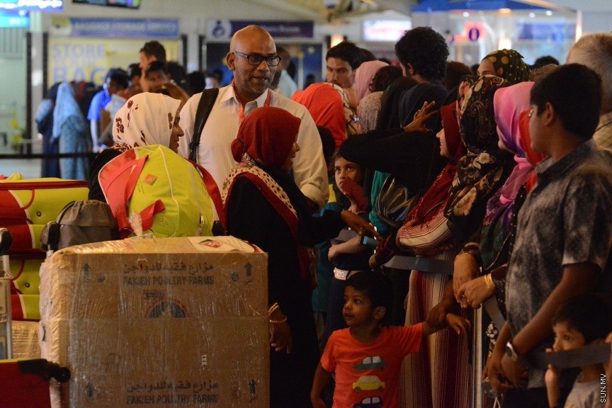 ދިވެހި ހައްޖާޖީއަކު އެއާޕޯޓުން ނުކުމެގެން އާއިލާއާ ބައްދަލުކުރަނީ --- ސަން ފޮޓޯ/ އަބްދުﷲ ހަފީޒް