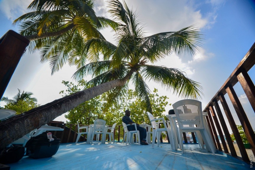 ކ. ހިންމަފޫށީ ގައި ހަދާފައި ހުރި ކެފޭއެއްގެ ތެރޭގައި މީހަކު ގޮނޑިއެއްގައި އިށީންދެގެން-- ސަން ފޮޓޯ/ މުހައްމަދު އަފްރާހް