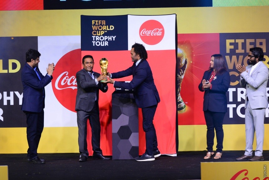 ކޮކާކޯލާ ވޯލްޑް ކަޕު ޓްރޮފީ ޓުއާގައި ފީފާ ވޯލްޑް ކަޕުގެ ތަށި ދިވެހިރާއްޖޭގައި ރަސްމީކޮށް ދައްކާލުމަށް ގައުމީ ފުޓްބޯޅަ ދަނޑުގައި ބޭއްވި ރަސްމިއްޔާތުގެ ތެރެއިން:  މި ހަފްލާގައި ފްރާންސްގެ ފުޓުބޯޅަ ލެޖެންޑް ކްރިސްޓިއަން ކްރެމްބޭއާއެކު ރައީސް ޔާމީން ވަނީ ފީފާ ވޯލްޑް ކަޕުގެ އޮރިޖިނަލް ޓްރޮފީ އުފުލައިލާފަ---ސަން ފޮޓޯ/ މުހައްމަދު އަފްރާހް 