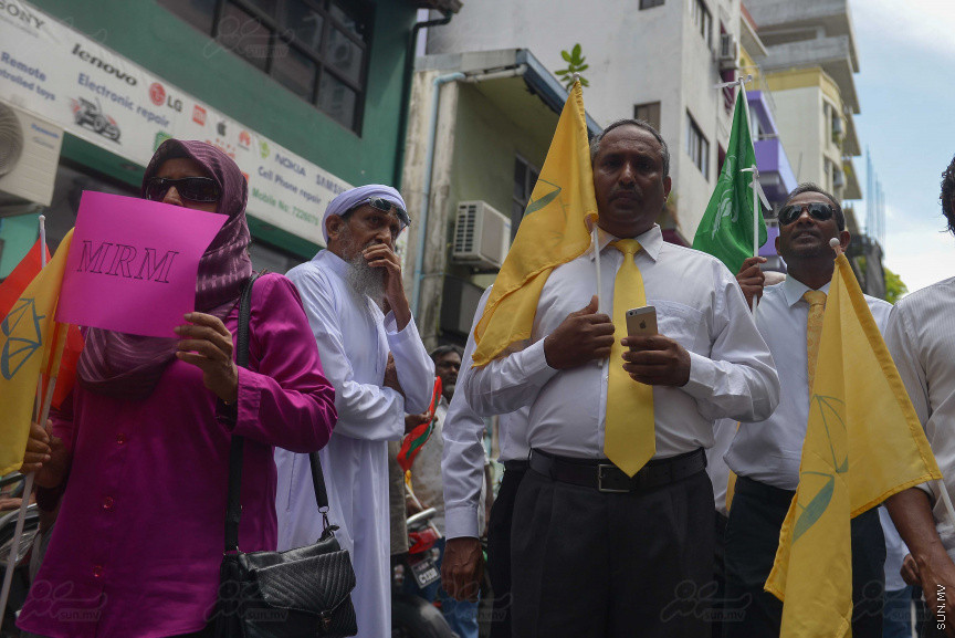 ޖުލައި 26، 2018: އިދިކޮޅު ރިޔާސީ ކެންޑިޑޭޓު އިބްރާހިމް މުހައްމަދު ސޯލިހު (އިބޫ) ގެ ކެންޑިޑެންސީ ފޯމު ހުށަހެޅުއްވުމަށް އިލެކްޝަންސް އަށް ވަޑައިގަންނަވަނީ: ގިނަ އަދަދެއްގެ ބަޔަކު އިބޫއާ އެކު އެމްޑީޕީ އޮފީހުން ފެށިގެން އިލެކްޝަންސް ކޮމިޝަނުގެ އިދާރާއަށް ގޮސްފައިވަނީ ބެރު ޖަހަމުން ހިނގާފައި  --- ސަންފޮޓޯ/ މުހައްމަދު އަފްރާހް