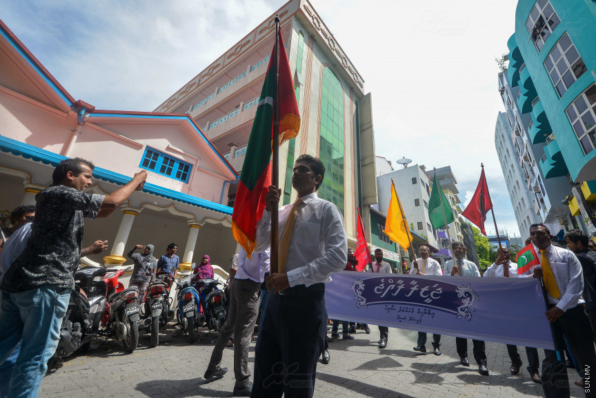 ޖުލައި 26، 2018: އިދިކޮޅު ރިޔާސީ ކެންޑިޑޭޓު އިބްރާހިމް މުހައްމަދު ސޯލިހު (އިބޫ) ގެ ކެންޑިޑެންސީ ފޯމު ހުށަހެޅުއްވުމަށް އިލެކްޝަންސް އަށް ވަޑައިގަންނަވަނީ: ގިނަ އަދަދެއްގެ ބަޔަކު އިބޫއާ އެކު އެމްޑީޕީ އޮފީހުން ފެށިގެން އިލެކްޝަންސް ކޮމިޝަނުގެ އިދާރާއަށް ގޮސްފައިވަނީ ބެރު ޖަހަމުން ހިނގާފައި  --- ސަންފޮޓޯ/ މުހައްމަދު އަފްރާހް