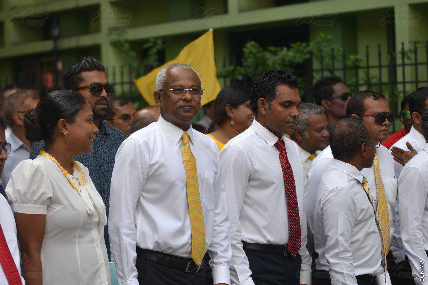 ޖުލައި 26، 2018: އިދިކޮޅު ރިޔާސީ ކެންޑިޑޭޓު އިބްރާހިމް މުހައްމަދު ސޯލިހު (އިބޫ) ގެ ކެންޑިޑެންސީ ފޯމު ހުށަހެޅުއްވުމަށް އިލެކްޝަންސް އަށް ވަޑައިގަންނަވަނީ: ގިނަ އަދަދެއްގެ ބަޔަކު އިބޫއާ އެކު އެމްޑީޕީ އޮފީހުން ފެށިގެން އިލެކްޝަންސް ކޮމިޝަނުގެ އިދާރާއަށް ގޮސްފައިވަނީ ބެރު ޖަހަމުން ހިނގާފައި  --- ސަންފޮޓޯ/ މުހައްމަދު އަފްރާހް