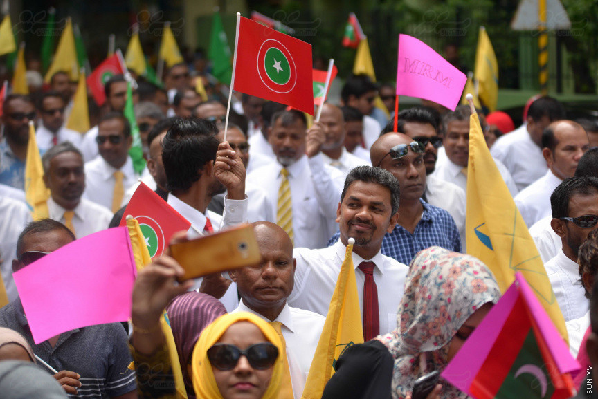 ޖުލައި 26، 2018: އިދިކޮޅު ރިޔާސީ ކެންޑިޑޭޓު އިބްރާހިމް މުހައްމަދު ސޯލިހު (އިބޫ) ގެ ކެންޑިޑެންސީ ފޯމު ހުށަހެޅުއްވުމަށް އިލެކްޝަންސް އަށް ވަޑައިގަންނަވަނީ: ގިނަ އަދަދެއްގެ ބަޔަކު އިބޫއާ އެކު އެމްޑީޕީ އޮފީހުން ފެށިގެން އިލެކްޝަންސް ކޮމިޝަނުގެ އިދާރާއަށް ގޮސްފައިވަނީ ބެރު ޖަހަމުން ހިނގާފައި  --- ސަންފޮޓޯ/ މުހައްމަދު އަފްރާހް