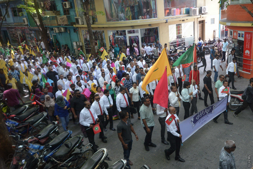 ޖުލައި 26، 2018: އިދިކޮޅު ރިޔާސީ ކެންޑިޑޭޓު އިބްރާހިމް މުހައްމަދު ސޯލިހު (އިބޫ) ގެ ކެންޑިޑެންސީ ފޯމު ހުށަހެޅުއްވުމަށް އިލެކްޝަންސް އަށް ވަޑައިގަންނަވަނީ: ގިނަ އަދަދެއްގެ ބަޔަކު އިބޫއާ އެކު އެމްޑީޕީ އޮފީހުން ފެށިގެން އިލެކްޝަންސް ކޮމިޝަނުގެ އިދާރާއަށް ގޮސްފައިވަނީ ބެރު ޖަހަމުން ހިނގާފައި  --- ސަންފޮޓޯ/ މުހައްމަދު އަފްރާހް