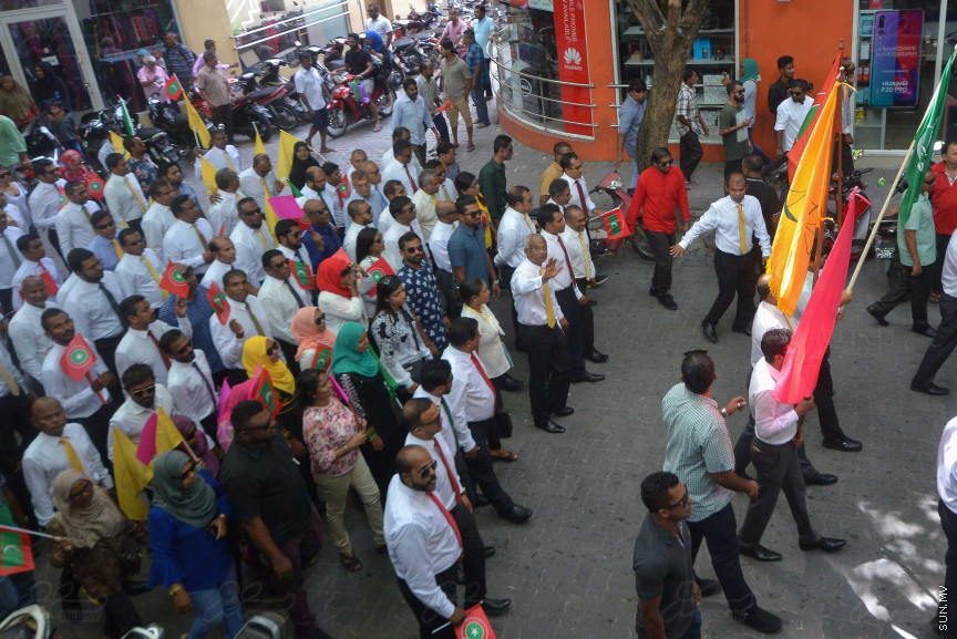 ޖުލައި 26، 2018: އިދިކޮޅު ރިޔާސީ ކެންޑިޑޭޓު އިބްރާހިމް މުހައްމަދު ސޯލިހު (އިބޫ) ގެ ކެންޑިޑެންސީ ފޯމު ހުށަހެޅުއްވުމަށް އިލެކްޝަންސް އަށް ވަޑައިގަންނަވަނީ: ގިނަ އަދަދެއްގެ ބަޔަކު އިބޫއާ އެކު އެމްޑީޕީ އޮފީހުން ފެށިގެން އިލެކްޝަންސް ކޮމިޝަނުގެ އިދާރާއަށް ގޮސްފައިވަނީ ބެރު ޖަހަމުން ހިނގާފައި  --- ސަންފޮޓޯ/ މުހައްމަދު އަފްރާހް
