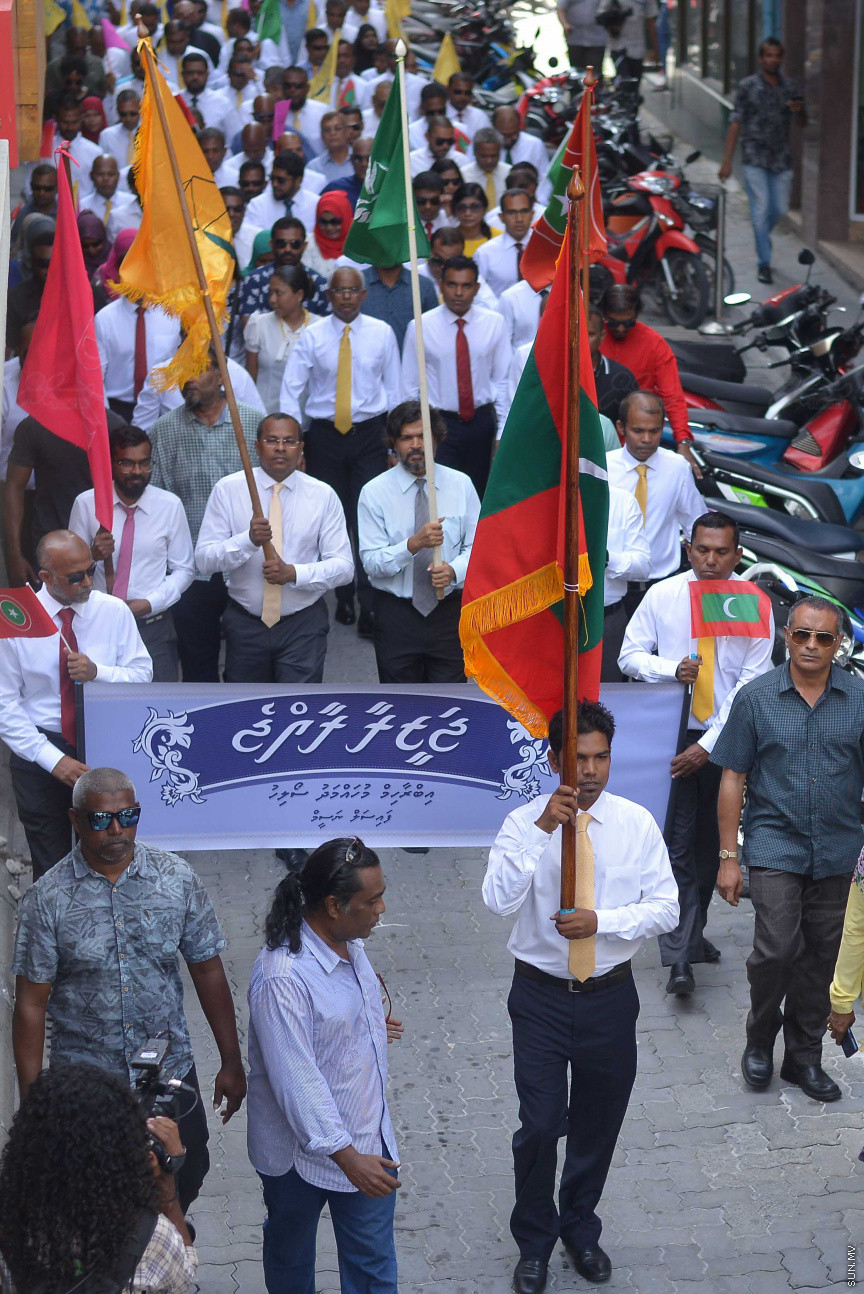 ޖުލައި 26، 2018: އިދިކޮޅު ރިޔާސީ ކެންޑިޑޭޓު އިބްރާހިމް މުހައްމަދު ސޯލިހު (އިބޫ) ގެ ކެންޑިޑެންސީ ފޯމު ހުށަހެޅުއްވުމަށް އިލެކްޝަންސް އަށް ވަޑައިގަންނަވަނީ: ގިނަ އަދަދެއްގެ ބަޔަކު އިބޫއާ އެކު އެމްޑީޕީ އޮފީހުން ފެށިގެން އިލެކްޝަންސް ކޮމިޝަނުގެ އިދާރާއަށް ގޮސްފައިވަނީ ބެރު ޖަހަމުން ހިނގާފައި  --- ސަންފޮޓޯ/ މުހައްމަދު އަފްރާހް