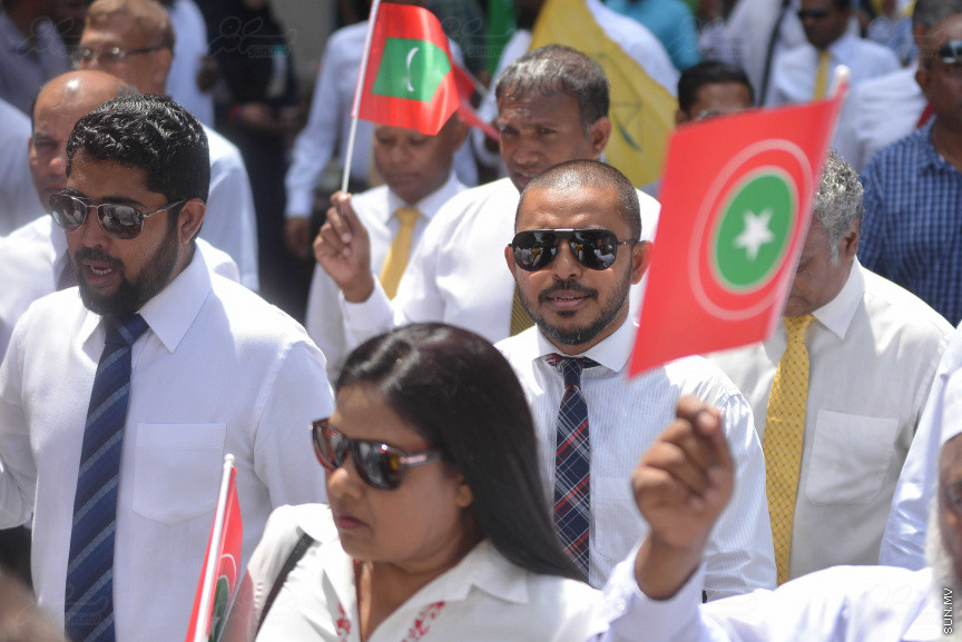 ޖުލައި 26، 2018: އިދިކޮޅު ރިޔާސީ ކެންޑިޑޭޓު އިބްރާހިމް މުހައްމަދު ސޯލިހު (އިބޫ) ގެ ކެންޑިޑެންސީ ފޯމު ހުށަހެޅުއްވުމަށް އިލެކްޝަންސް އަށް ވަޑައިގަންނަވަނީ: ގިނަ އަދަދެއްގެ ބަޔަކު އިބޫއާ އެކު އެމްޑީޕީ އޮފީހުން ފެށިގެން އިލެކްޝަންސް ކޮމިޝަނުގެ އިދާރާއަށް ގޮސްފައިވަނީ ބެރު ޖަހަމުން ހިނގާފައި  --- ސަންފޮޓޯ/ މުހައްމަދު އަފްރާހް