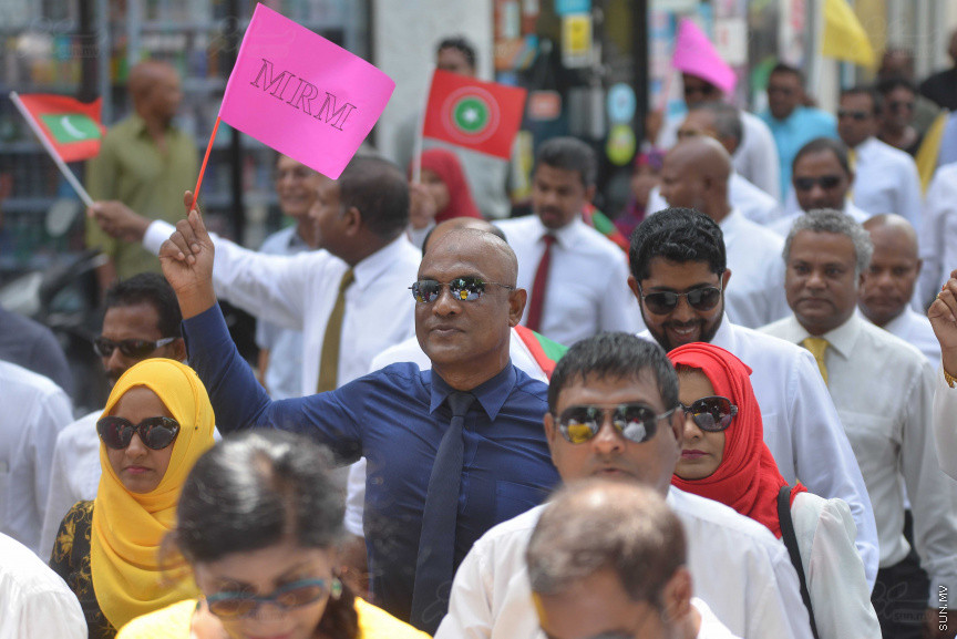 ޖުލައި 26، 2018: އިދިކޮޅު ރިޔާސީ ކެންޑިޑޭޓު އިބްރާހިމް މުހައްމަދު ސޯލިހު (އިބޫ) ގެ ކެންޑިޑެންސީ ފޯމު ހުށަހެޅުއްވުމަށް އިލެކްޝަންސް އަށް ވަޑައިގަންނަވަނީ: ގިނަ އަދަދެއްގެ ބަޔަކު އިބޫއާ އެކު އެމްޑީޕީ އޮފީހުން ފެށިގެން އިލެކްޝަންސް ކޮމިޝަނުގެ އިދާރާއަށް ގޮސްފައިވަނީ ބެރު ޖަހަމުން ހިނގާފައި  --- ސަންފޮޓޯ/ މުހައްމަދު އަފްރާހް