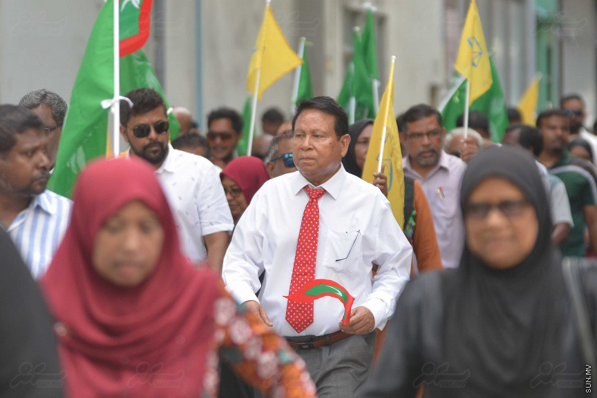ޖުލައި 26، 2018: އިދިކޮޅު ރިޔާސީ ކެންޑިޑޭޓު އިބްރާހިމް މުހައްމަދު ސޯލިހު (އިބޫ) ގެ ކެންޑިޑެންސީ ފޯމު ހުށަހެޅުއްވުމަށް އިލެކްޝަންސް އަށް ވަޑައިގަންނަވަނީ: ގިނަ އަދަދެއްގެ ބަޔަކު އިބޫއާ އެކު އެމްޑީޕީ އޮފީހުން ފެށިގެން އިލެކްޝަންސް ކޮމިޝަނުގެ އިދާރާއަށް ގޮސްފައިވަނީ ބެރު ޖަހަމުން ހިނގާފައި  --- ސަންފޮޓޯ/ މުހައްމަދު އަފްރާހް