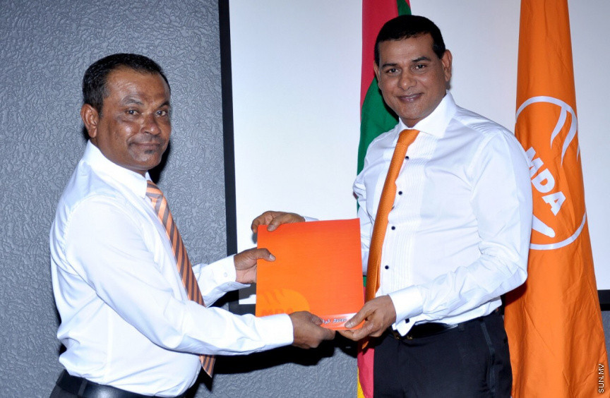 މޯލްޑިވްސް ޑިވަލޮޕްމެންޓް އެލަޔަންސް (އެމްޑީއޭ)ގެ ޓިކެޓްގައި ރައްޔިތުންގެ މަޖިލީހުގެ އިންތިހާބަށް ވާދަ ކުރުމަށް އަށް ބޭފުޅަކަށް ރޭ ޓިކެޓް ދިނުން -- ޕޮޓޯ/ އެމްޑީއޭ