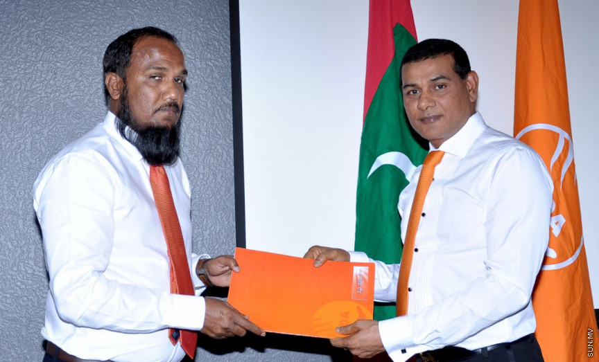މޯލްޑިވްސް ޑިވަލޮޕްމެންޓް އެލަޔަންސް (އެމްޑީއޭ)ގެ ޓިކެޓްގައި ރައްޔިތުންގެ މަޖިލީހުގެ އިންތިހާބަށް ވާދަ ކުރުމަށް އަށް ބޭފުޅަކަށް ރޭ ޓިކެޓް ދިނުން -- ޕޮޓޯ/ އެމްޑީއޭ