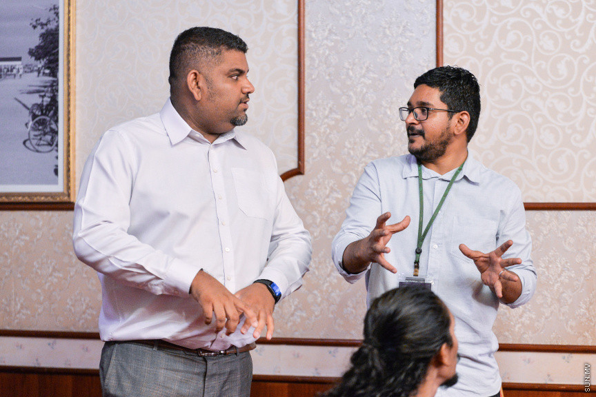މާޗް 27، 2020: ކޮވިޑް19ގެ ނުރައްކާ ރާއްޖެއަށް ބޮޑުވެ، މުޅި ރާއްޖޭގައި ސިއްހީ ކުއްލި ނުރައްކާ އިއުލާން ކުރީ މި މަހުގެ 12 ވަނަ ދުވަހުއެވެ. އޭގެ ކުރިން ވެސް ކޮވިޑް19ގެ ހާލަތު އޮތް މިންވަރު ސަރުކާރުން ދިޔައީ ބުނެދެމުންނެވެ. ކޮވިޑް-19ގެ ތަރުޖާމާނެއްގެ ގޮތުގުގައި ރައީސް އޮފީހުގެ އަންޑަ ސެކްރެޓަރީ މަބްރޫކް އަބްދުލް އަޒީޒް ކަނޑައެޅުމާ އެކު ކޮންމެ ދުވަހަކު އެ ބޭފުޅާ ގެންދަވަނީ މީޑިއާތަކަށް މައުލޫމާތު ދެއްވަމުންނެވެ. ހުކުރު ދުވަސް ފިޔަވައި ކޮންމެ ދުވަަކު ދެ އިރު ޕްރެސް ކޮންފަރެންސް ދެއްވައެވެ. ހުކުރު ދުވަހުގެ ރޭ ވެސް ޕްރެސް ދެއްވައެވެ. ސަރުކާރު ބަންދުކޮށް، ކެފޭތަކާއި ރެސްޓޯރަންތުތައް ބަންދުކޮށްފައިވުމުން، ގޭގައި ތިބެގެން ގިނަ ބަޔަކު މަބްރޫކް ބާއްވާ ޕްރެސް ކޮންފަރެންސްތައް ދަނީ ބަލަމުންނެވެ. މި ފޮޓޯތަކުން މި ފެންނަނީ އެ ޕްރެސް ކޮންފަރެންސްތަކުގެ އަނެއް ފަރާތެވެ -- ސަން ފޮޓޯ/ ފަޔާޒު މޫސާ