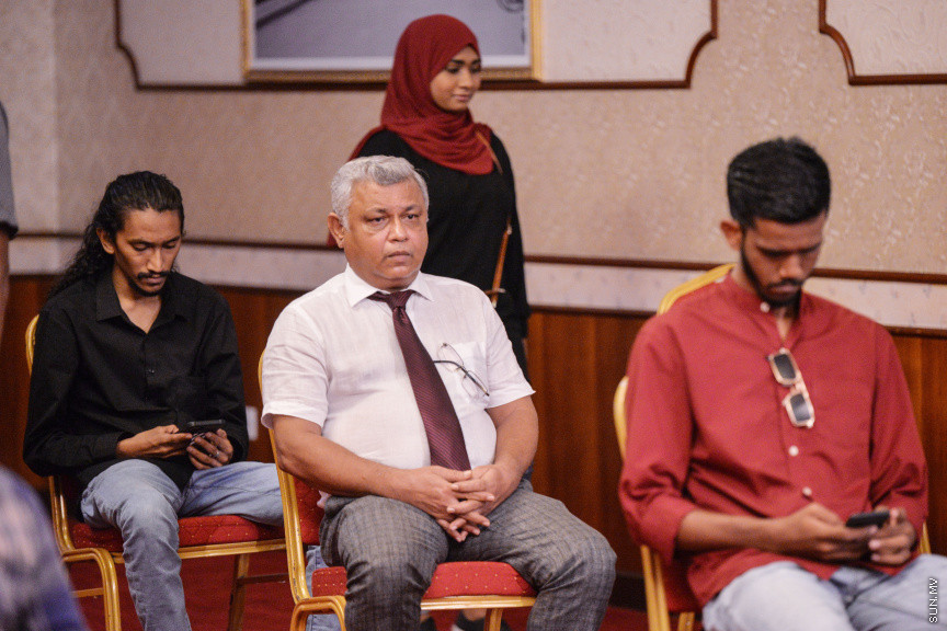 މާޗް 27، 2020: ކޮވިޑް19ގެ ނުރައްކާ ރާއްޖެއަށް ބޮޑުވެ، މުޅި ރާއްޖޭގައި ސިއްހީ ކުއްލި ނުރައްކާ އިއުލާން ކުރީ މި މަހުގެ 12 ވަނަ ދުވަހުއެވެ. އޭގެ ކުރިން ވެސް ކޮވިޑް19ގެ ހާލަތު އޮތް މިންވަރު ސަރުކާރުން ދިޔައީ ބުނެދެމުންނެވެ. ކޮވިޑް-19ގެ ތަރުޖާމާނެއްގެ ގޮތުގުގައި ރައީސް އޮފީހުގެ އަންޑަ ސެކްރެޓަރީ މަބްރޫކް އަބްދުލް އަޒީޒް ކަނޑައެޅުމާ އެކު ކޮންމެ ދުވަހަކު އެ ބޭފުޅާ ގެންދަވަނީ މީޑިއާތަކަށް މައުލޫމާތު ދެއްވަމުންނެވެ. ހުކުރު ދުވަސް ފިޔަވައި ކޮންމެ ދުވަަކު ދެ އިރު ޕްރެސް ކޮންފަރެންސް ދެއްވައެވެ. ހުކުރު ދުވަހުގެ ރޭ ވެސް ޕްރެސް ދެއްވައެވެ. ސަރުކާރު ބަންދުކޮށް، ކެފޭތަކާއި ރެސްޓޯރަންތުތައް ބަންދުކޮށްފައިވުމުން، ގޭގައި ތިބެގެން ގިނަ ބަޔަކު މަބްރޫކް ބާއްވާ ޕްރެސް ކޮންފަރެންސްތައް ދަނީ ބަލަމުންނެވެ. މި ފޮޓޯތަކުން މި ފެންނަނީ އެ ޕްރެސް ކޮންފަރެންސްތަކުގެ އަނެއް ފަރާތެވެ -- ސަން ފޮޓޯ/ ފަޔާޒު މޫސާ