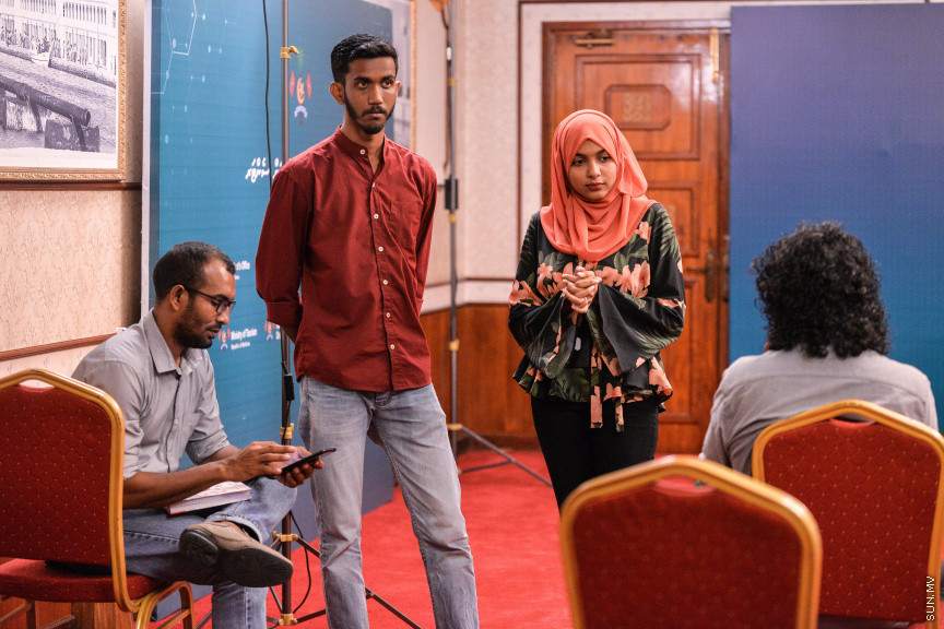 މާޗް 27، 2020: ކޮވިޑް19ގެ ނުރައްކާ ރާއްޖެއަށް ބޮޑުވެ، މުޅި ރާއްޖޭގައި ސިއްހީ ކުއްލި ނުރައްކާ އިއުލާން ކުރީ މި މަހުގެ 12 ވަނަ ދުވަހުއެވެ. އޭގެ ކުރިން ވެސް ކޮވިޑް19ގެ ހާލަތު އޮތް މިންވަރު ސަރުކާރުން ދިޔައީ ބުނެދެމުންނެވެ. ކޮވިޑް-19ގެ ތަރުޖާމާނެއްގެ ގޮތުގުގައި ރައީސް އޮފީހުގެ އަންޑަ ސެކްރެޓަރީ މަބްރޫކް އަބްދުލް އަޒީޒް ކަނޑައެޅުމާ އެކު ކޮންމެ ދުވަހަކު އެ ބޭފުޅާ ގެންދަވަނީ މީޑިއާތަކަށް މައުލޫމާތު ދެއްވަމުންނެވެ. ހުކުރު ދުވަސް ފިޔަވައި ކޮންމެ ދުވަަކު ދެ އިރު ޕްރެސް ކޮންފަރެންސް ދެއްވައެވެ. ހުކުރު ދުވަހުގެ ރޭ ވެސް ޕްރެސް ދެއްވައެވެ. ސަރުކާރު ބަންދުކޮށް، ކެފޭތަކާއި ރެސްޓޯރަންތުތައް ބަންދުކޮށްފައިވުމުން، ގޭގައި ތިބެގެން ގިނަ ބަޔަކު މަބްރޫކް ބާއްވާ ޕްރެސް ކޮންފަރެންސްތައް ދަނީ ބަލަމުންނެވެ. މި ފޮޓޯތަކުން މި ފެންނަނީ އެ ޕްރެސް ކޮންފަރެންސްތަކުގެ އަނެއް ފަރާތެވެ -- ސަން ފޮޓޯ/ ފަޔާޒު މޫސާ