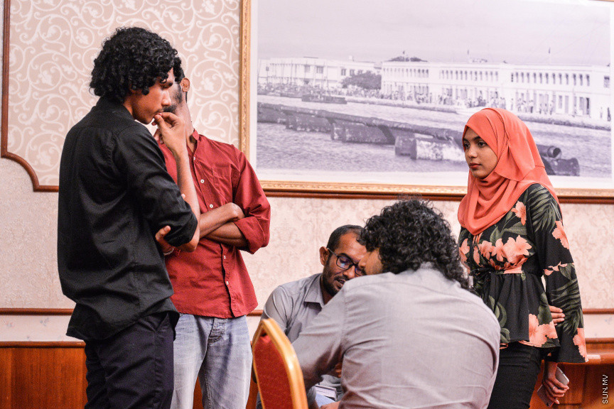 މާޗް 27، 2020: ކޮވިޑް19ގެ ނުރައްކާ ރާއްޖެއަށް ބޮޑުވެ، މުޅި ރާއްޖޭގައި ސިއްހީ ކުއްލި ނުރައްކާ އިއުލާން ކުރީ މި މަހުގެ 12 ވަނަ ދުވަހުއެވެ. އޭގެ ކުރިން ވެސް ކޮވިޑް19ގެ ހާލަތު އޮތް މިންވަރު ސަރުކާރުން ދިޔައީ ބުނެދެމުންނެވެ. ކޮވިޑް-19ގެ ތަރުޖާމާނެއްގެ ގޮތުގުގައި ރައީސް އޮފީހުގެ އަންޑަ ސެކްރެޓަރީ މަބްރޫކް އަބްދުލް އަޒީޒް ކަނޑައެޅުމާ އެކު ކޮންމެ ދުވަހަކު އެ ބޭފުޅާ ގެންދަވަނީ މީޑިއާތަކަށް މައުލޫމާތު ދެއްވަމުންނެވެ. ހުކުރު ދުވަސް ފިޔަވައި ކޮންމެ ދުވަަކު ދެ އިރު ޕްރެސް ކޮންފަރެންސް ދެއްވައެވެ. ހުކުރު ދުވަހުގެ ރޭ ވެސް ޕްރެސް ދެއްވައެވެ. ސަރުކާރު ބަންދުކޮށް، ކެފޭތަކާއި ރެސްޓޯރަންތުތައް ބަންދުކޮށްފައިވުމުން، ގޭގައި ތިބެގެން ގިނަ ބަޔަކު މަބްރޫކް ބާއްވާ ޕްރެސް ކޮންފަރެންސްތައް ދަނީ ބަލަމުންނެވެ. މި ފޮޓޯތަކުން މި ފެންނަނީ އެ ޕްރެސް ކޮންފަރެންސްތަކުގެ އަނެއް ފަރާތެވެ -- ސަން ފޮޓޯ/ ފަޔާޒު މޫސާ