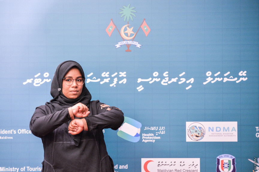 މާޗް 27، 2020: ކޮވިޑް19ގެ ނުރައްކާ ރާއްޖެއަށް ބޮޑުވެ، މުޅި ރާއްޖޭގައި ސިއްހީ ކުއްލި ނުރައްކާ އިއުލާން ކުރީ މި މަހުގެ 12 ވަނަ ދުވަހުއެވެ. އޭގެ ކުރިން ވެސް ކޮވިޑް19ގެ ހާލަތު އޮތް މިންވަރު ސަރުކާރުން ދިޔައީ ބުނެދެމުންނެވެ. ކޮވިޑް-19ގެ ތަރުޖާމާނެއްގެ ގޮތުގުގައި ރައީސް އޮފީހުގެ އަންޑަ ސެކްރެޓަރީ މަބްރޫކް އަބްދުލް އަޒީޒް ކަނޑައެޅުމާ އެކު ކޮންމެ ދުވަހަކު އެ ބޭފުޅާ ގެންދަވަނީ މީޑިއާތަކަށް މައުލޫމާތު ދެއްވަމުންނެވެ. ހުކުރު ދުވަސް ފިޔަވައި ކޮންމެ ދުވަަކު ދެ އިރު ޕްރެސް ކޮންފަރެންސް ދެއްވައެވެ. ހުކުރު ދުވަހުގެ ރޭ ވެސް ޕްރެސް ދެއްވައެވެ. ސަރުކާރު ބަންދުކޮށް، ކެފޭތަކާއި ރެސްޓޯރަންތުތައް ބަންދުކޮށްފައިވުމުން، ގޭގައި ތިބެގެން ގިނަ ބަޔަކު މަބްރޫކް ބާއްވާ ޕްރެސް ކޮންފަރެންސްތައް ދަނީ ބަލަމުންނެވެ. މި ފޮޓޯތަކުން މި ފެންނަނީ އެ ޕްރެސް ކޮންފަރެންސްތަކުގެ އަނެއް ފަރާތެވެ -- ސަން ފޮޓޯ/ ފަޔާޒު މޫސާ