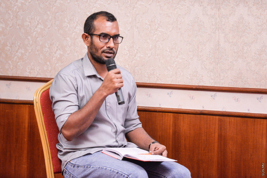 މާޗް 27، 2020: ކޮވިޑް19ގެ ނުރައްކާ ރާއްޖެއަށް ބޮޑުވެ، މުޅި ރާއްޖޭގައި ސިއްހީ ކުއްލި ނުރައްކާ އިއުލާން ކުރީ މި މަހުގެ 12 ވަނަ ދުވަހުއެވެ. އޭގެ ކުރިން ވެސް ކޮވިޑް19ގެ ހާލަތު އޮތް މިންވަރު ސަރުކާރުން ދިޔައީ ބުނެދެމުންނެވެ. ކޮވިޑް-19ގެ ތަރުޖާމާނެއްގެ ގޮތުގުގައި ރައީސް އޮފީހުގެ އަންޑަ ސެކްރެޓަރީ މަބްރޫކް އަބްދުލް އަޒީޒް ކަނޑައެޅުމާ އެކު ކޮންމެ ދުވަހަކު އެ ބޭފުޅާ ގެންދަވަނީ މީޑިއާތަކަށް މައުލޫމާތު ދެއްވަމުންނެވެ. ހުކުރު ދުވަސް ފިޔަވައި ކޮންމެ ދުވަަކު ދެ އިރު ޕްރެސް ކޮންފަރެންސް ދެއްވައެވެ. ހުކުރު ދުވަހުގެ ރޭ ވެސް ޕްރެސް ދެއްވައެވެ. ސަރުކާރު ބަންދުކޮށް، ކެފޭތަކާއި ރެސްޓޯރަންތުތައް ބަންދުކޮށްފައިވުމުން، ގޭގައި ތިބެގެން ގިނަ ބަޔަކު މަބްރޫކް ބާއްވާ ޕްރެސް ކޮންފަރެންސްތައް ދަނީ ބަލަމުންނެވެ. މި ފޮޓޯތަކުން މި ފެންނަނީ އެ ޕްރެސް ކޮންފަރެންސްތަކުގެ އަނެއް ފަރާތެވެ -- ސަން ފޮޓޯ/ ފަޔާޒު މޫސާ