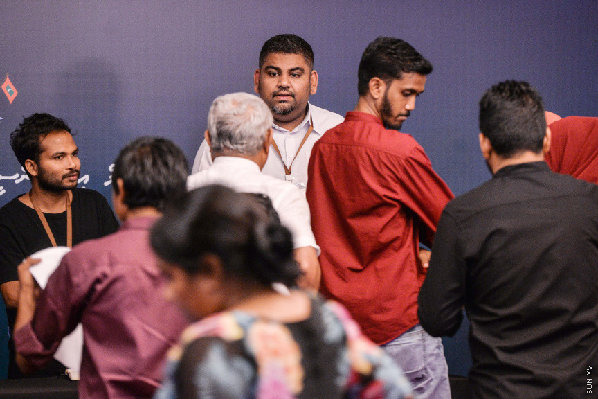 މާޗް 27، 2020: ކޮވިޑް19ގެ ނުރައްކާ ރާއްޖެއަށް ބޮޑުވެ، މުޅި ރާއްޖޭގައި ސިއްހީ ކުއްލި ނުރައްކާ އިއުލާން ކުރީ މި މަހުގެ 12 ވަނަ ދުވަހުއެވެ. އޭގެ ކުރިން ވެސް ކޮވިޑް19ގެ ހާލަތު އޮތް މިންވަރު ސަރުކާރުން ދިޔައީ ބުނެދެމުންނެވެ. ކޮވިޑް-19ގެ ތަރުޖާމާނެއްގެ ގޮތުގުގައި ރައީސް އޮފީހުގެ އަންޑަ ސެކްރެޓަރީ މަބްރޫކް އަބްދުލް އަޒީޒް ކަނޑައެޅުމާ އެކު ކޮންމެ ދުވަހަކު އެ ބޭފުޅާ ގެންދަވަނީ މީޑިއާތަކަށް މައުލޫމާތު ދެއްވަމުންނެވެ. ހުކުރު ދުވަސް ފިޔަވައި ކޮންމެ ދުވަަކު ދެ އިރު ޕްރެސް ކޮންފަރެންސް ދެއްވައެވެ. ހުކުރު ދުވަހުގެ ރޭ ވެސް ޕްރެސް ދެއްވައެވެ. ސަރުކާރު ބަންދުކޮށް، ކެފޭތަކާއި ރެސްޓޯރަންތުތައް ބަންދުކޮށްފައިވުމުން، ގޭގައި ތިބެގެން ގިނަ ބަޔަކު މަބްރޫކް ބާއްވާ ޕްރެސް ކޮންފަރެންސްތައް ދަނީ ބަލަމުންނެވެ. މި ފޮޓޯތަކުން މި ފެންނަނީ އެ ޕްރެސް ކޮންފަރެންސްތަކުގެ އަނެއް ފަރާތެވެ -- ސަން ފޮޓޯ/ ފަޔާޒު މޫސާ