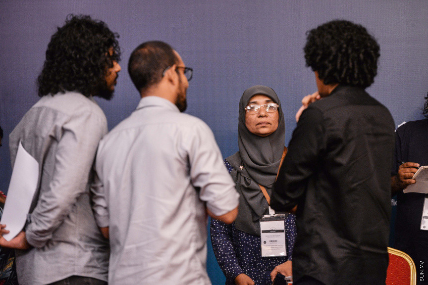 މާޗް 27، 2020: ކޮވިޑް19ގެ ނުރައްކާ ރާއްޖެއަށް ބޮޑުވެ، މުޅި ރާއްޖޭގައި ސިއްހީ ކުއްލި ނުރައްކާ އިއުލާން ކުރީ މި މަހުގެ 12 ވަނަ ދުވަހުއެވެ. އޭގެ ކުރިން ވެސް ކޮވިޑް19ގެ ހާލަތު އޮތް މިންވަރު ސަރުކާރުން ދިޔައީ ބުނެދެމުންނެވެ. ކޮވިޑް-19ގެ ތަރުޖާމާނެއްގެ ގޮތުގުގައި ރައީސް އޮފީހުގެ އަންޑަ ސެކްރެޓަރީ މަބްރޫކް އަބްދުލް އަޒީޒް ކަނޑައެޅުމާ އެކު ކޮންމެ ދުވަހަކު އެ ބޭފުޅާ ގެންދަވަނީ މީޑިއާތަކަށް މައުލޫމާތު ދެއްވަމުންނެވެ. ހުކުރު ދުވަސް ފިޔަވައި ކޮންމެ ދުވަަކު ދެ އިރު ޕްރެސް ކޮންފަރެންސް ދެއްވައެވެ. ހުކުރު ދުވަހުގެ ރޭ ވެސް ޕްރެސް ދެއްވައެވެ. ސަރުކާރު ބަންދުކޮށް، ކެފޭތަކާއި ރެސްޓޯރަންތުތައް ބަންދުކޮށްފައިވުމުން، ގޭގައި ތިބެގެން ގިނަ ބަޔަކު މަބްރޫކް ބާއްވާ ޕްރެސް ކޮންފަރެންސްތައް ދަނީ ބަލަމުންނެވެ. މި ފޮޓޯތަކުން މި ފެންނަނީ އެ ޕްރެސް ކޮންފަރެންސްތަކުގެ އަނެއް ފަރާތެވެ -- ސަން ފޮޓޯ/ ފަޔާޒު މޫސާ