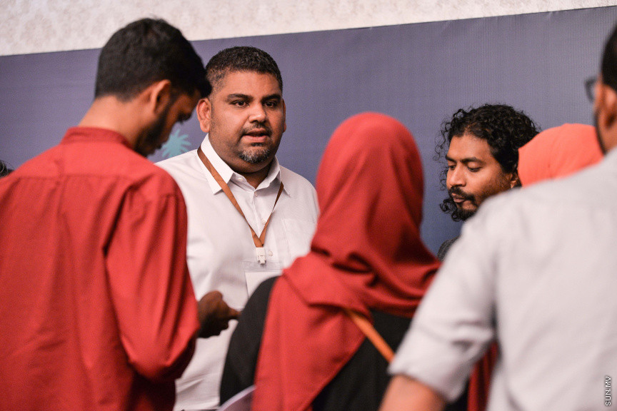 މާޗް 27، 2020: ކޮވިޑް19ގެ ނުރައްކާ ރާއްޖެއަށް ބޮޑުވެ، މުޅި ރާއްޖޭގައި ސިއްހީ ކުއްލި ނުރައްކާ އިއުލާން ކުރީ މި މަހުގެ 12 ވަނަ ދުވަހުއެވެ. އޭގެ ކުރިން ވެސް ކޮވިޑް19ގެ ހާލަތު އޮތް މިންވަރު ސަރުކާރުން ދިޔައީ ބުނެދެމުންނެވެ. ކޮވިޑް-19ގެ ތަރުޖާމާނެއްގެ ގޮތުގުގައި ރައީސް އޮފީހުގެ އަންޑަ ސެކްރެޓަރީ މަބްރޫކް އަބްދުލް އަޒީޒް ކަނޑައެޅުމާ އެކު ކޮންމެ ދުވަހަކު އެ ބޭފުޅާ ގެންދަވަނީ މީޑިއާތަކަށް މައުލޫމާތު ދެއްވަމުންނެވެ. ހުކުރު ދުވަސް ފިޔަވައި ކޮންމެ ދުވަަކު ދެ އިރު ޕްރެސް ކޮންފަރެންސް ދެއްވައެވެ. ހުކުރު ދުވަހުގެ ރޭ ވެސް ޕްރެސް ދެއްވައެވެ. ސަރުކާރު ބަންދުކޮށް، ކެފޭތަކާއި ރެސްޓޯރަންތުތައް ބަންދުކޮށްފައިވުމުން، ގޭގައި ތިބެގެން ގިނަ ބަޔަކު މަބްރޫކް ބާއްވާ ޕްރެސް ކޮންފަރެންސްތައް ދަނީ ބަލަމުންނެވެ. މި ފޮޓޯތަކުން މި ފެންނަނީ އެ ޕްރެސް ކޮންފަރެންސްތަކުގެ އަނެއް ފަރާތެވެ -- ސަން ފޮޓޯ/ ފަޔާޒު މޫސާ