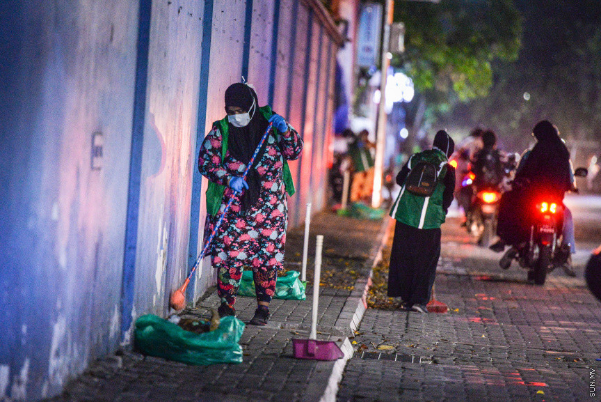 އޭޕްރީލް 8، 2020: ކޮވިޑް-19އިން ރައްކާތެރިވުމުގެ ފިޔަވަޅުތައް މުޅި ރާއްޖޭގައި އަޅަމުންދާއިރު، ފްރޮންޓްލައިންގައި މަސައްކަތް ކުރާ މީހުންގެ ތެރޭގައި ވެމްކޯގެ ކުނި ކަހާ އަންހެނުން ހިމެނޭ. ކޮންމެ ދުވަހަކު އެ މީހުން މަގުތައް ސާފު ކުރަން ނުކުންނަނީ އަމިއްލަ ނަފްސު ނުރައްކަލަށް ހުށަހަޅަމުން. އެ މީހުން ބުނާ ގޮތުގައި ބޭނުންކޮށްފައި ހުންނަ ޓިޝޫއާއި ފޭސް މާސްކުތައް މަގުމަތިން ކަހަން ޖެހޭ. އެ މީހުން އާދޭސްކޮށްފައި ބުނަނީ އެފަދަ ކުނި މަގުމައްޗަށް ނާޅަން -- ސަން ފޮޓޯ/ ފަޔާޒު މޫސާ