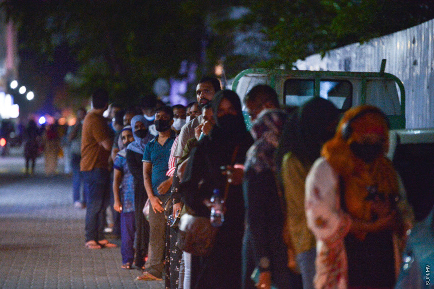 މޭ 1، 2021: ރަމަޟާން މަހު ވެކްސިން ޖަހައިދޭ ވަގުތު މަދުކުރުމުން ކޮންމެ ރެއަކުވެސް އެތައް ސަތޭކަ ބަޔަކު ވެކްސިން ޖަހަން ކިޔުއަށް އަރާ. މީގެ ކުރިން އޮންލައިންކޮށް ނަންބަރު ދޫކޮށްގެން ވެކްސިން ޖެހުމުގެ އިންތިޒާމް ހަމަޖައްސާފައި އޮތް ނަމަވެސް މިހާރު ރެއެއްގެ މައްޗަށް ވެކްސިން ޖަހައިދޭ މިންވަރު ލިމިޓް ކޮސް އޮންލައިންކޮށް ނަންބަރު ދޫ ކުރުން ވަނީ ހުއްޓާލައިފަ. ވެކްސިން ޖަހައިދޭ ސެންޓަރު ތަކުގެ އަދަދު ވެސް ލިމިޓް ކުރުމާއެކު ވެކްސިން ކިޔުތަކަށް ވަނީ އިތުރަށް ބާރު ބޮޑުވެފައި. ގައިދުރުކަމެއް ނެތި ވެކްސިން ކިޔުތަކުގައި ތިން ހަތަރު ގަޑިއިރު ހޭދަކުރަން ޖެހުމަކީ ބޮޑު ތަކުލީފަކަށް ވަނީ ވެފައި. ރާއްޖެއިން މިހާތަނަށް 296،000 އަށް ވުރެ ގިނަ މީހުން ވެކްސިން ގެ ފުރަތަމަ ޑޯޒް އަދި 102،500 އަށް ވުރެ ގިނަ މީހުން ވެކްސިން ގެ ދެ ޑޯޒް ވަނީ ފުރިހަމަ ކޮށްފައި -- ސަން ފޮޓޯ/ ފަޔާޒު މޫސާ