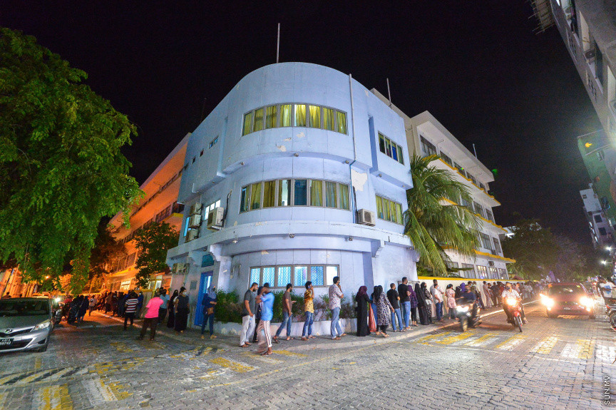 މޭ 1، 2021: ރަމަޟާން މަހު ވެކްސިން ޖަހައިދޭ ވަގުތު މަދުކުރުމުން ކޮންމެ ރެއަކުވެސް އެތައް ސަތޭކަ ބަޔަކު ވެކްސިން ޖަހަން ކިޔުއަށް އަރާ. މީގެ ކުރިން އޮންލައިންކޮށް ނަންބަރު ދޫކޮށްގެން ވެކްސިން ޖެހުމުގެ އިންތިޒާމް ހަމަޖައްސާފައި އޮތް ނަމަވެސް މިހާރު ރެއެއްގެ މައްޗަށް ވެކްސިން ޖަހައިދޭ މިންވަރު ލިމިޓް ކޮސް އޮންލައިންކޮށް ނަންބަރު ދޫ ކުރުން ވަނީ ހުއްޓާލައިފަ. ވެކްސިން ޖަހައިދޭ ސެންޓަރު ތަކުގެ އަދަދު ވެސް ލިމިޓް ކުރުމާއެކު ވެކްސިން ކިޔުތަކަށް ވަނީ އިތުރަށް ބާރު ބޮޑުވެފައި. ގައިދުރުކަމެއް ނެތި ވެކްސިން ކިޔުތަކުގައި ތިން ހަތަރު ގަޑިއިރު ހޭދަކުރަން ޖެހުމަކީ ބޮޑު ތަކުލީފަކަށް ވަނީ ވެފައި. ރާއްޖެއިން މިހާތަނަށް 296،000 އަށް ވުރެ ގިނަ މީހުން ވެކްސިން ގެ ފުރަތަމަ ޑޯޒް އަދި 102،500 އަށް ވުރެ ގިނަ މީހުން ވެކްސިން ގެ ދެ ޑޯޒް ވަނީ ފުރިހަމަ ކޮށްފައި -- ސަން ފޮޓޯ/ ފަޔާޒު މޫސާ