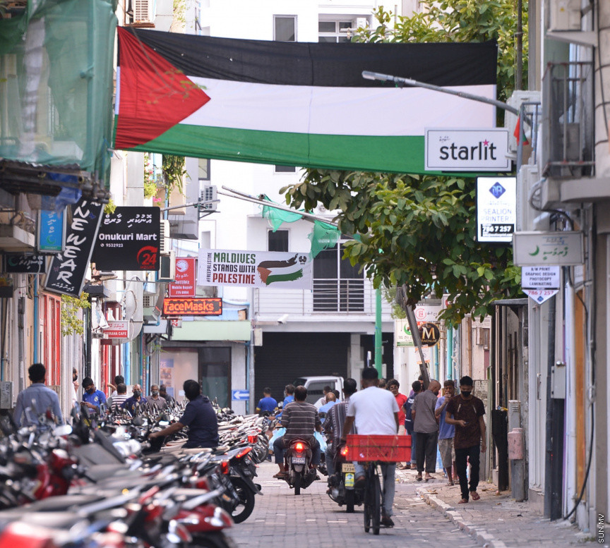 މެއި 19، 2021: ދިވެހީން ތިބީ ފަލަސްތީނާއެކުކަން ހާމަކުރުމުގެ ގޮތުން މުޅި މާލެތެރޭގައި ފަލަސްތީނުގެ ދިދަ: ދުނިޔޭގެ އެހެން ގައުމުތަކުން ފަލަސްތީނާއެކު ތިބިކަން ހާމަކޮށް އެއްވުންތައް ބޭއްވި ނަމަވެސް ކޮވިޑް ކާފިއުއާ ގުޅިގެން މާލޭގައި މިކަން ކުރީ އެމީހެއްގެ އަމިއްލަ ގޭގައި ތިބެގެން ފަލަސްތީނު ދިދަ ވިހުރުވައިގެން. އެހެން ނަމަވެސް މަދުމަދުން މަގުމައްޗަށް  ބައެއް މީހުން ނުކުމެ ޝުއޫރު ފާޅުކުރި --- ސަން ފޮޓޯ/ މުހައްމަދު މުޒައްޔިން ނާޒިމް