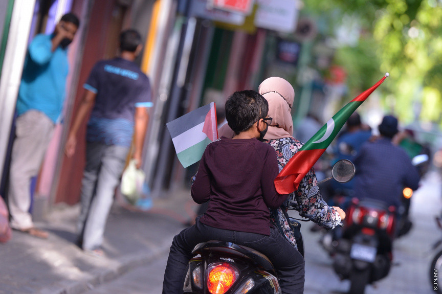 މެއި 19، 2021: ދިވެހީން ތިބީ ފަލަސްތީނާއެކުކަން ހާމަކުރުމުގެ ގޮތުން މުޅި މާލެތެރޭގައި ފަލަސްތީނުގެ ދިދަ: ދުނިޔޭގެ އެހެން ގައުމުތަކުން ފަލަސްތީނާއެކު ތިބިކަން ހާމަކޮށް އެއްވުންތައް ބޭއްވި ނަމަވެސް ކޮވިޑް ކާފިއުއާ ގުޅިގެން މާލޭގައި މިކަން ކުރީ އެމީހެއްގެ އަމިއްލަ ގޭގައި ތިބެގެން ފަލަސްތީނު ދިދަ ވިހުރުވައިގެން. އެހެން ނަމަވެސް މަދުމަދުން މަގުމައްޗަށް  ބައެއް މީހުން ނުކުމެ ޝުއޫރު ފާޅުކުރި --- ސަން ފޮޓޯ/ މުހައްމަދު މުޒައްޔިން ނާޒިމް