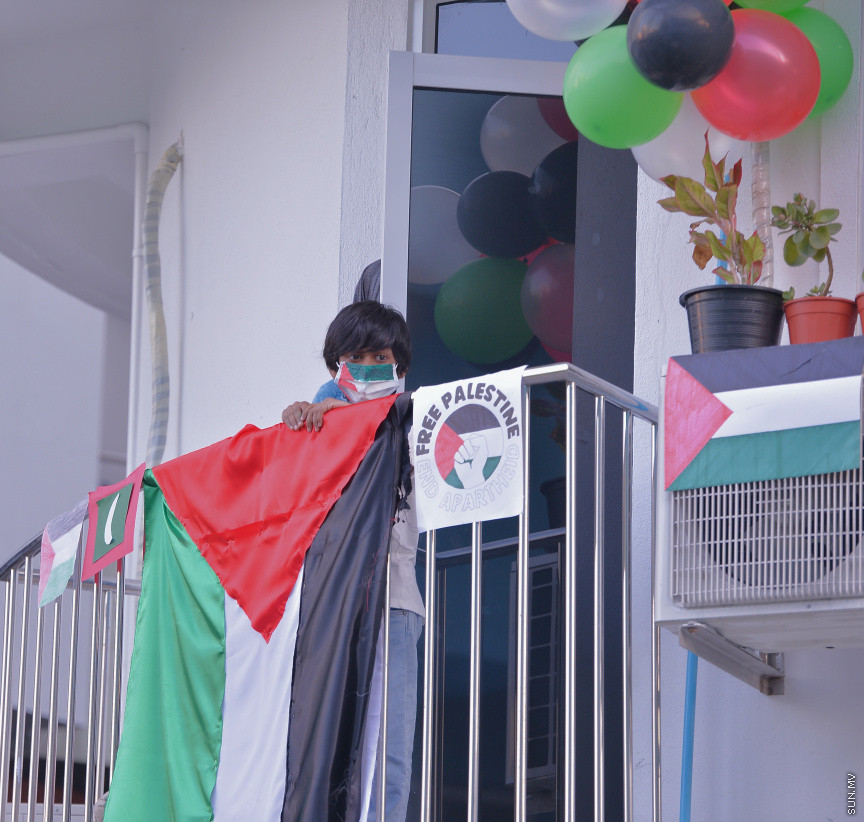 މެއި 19، 2021: ދިވެހީން ތިބީ ފަލަސްތީނާއެކުކަން ހާމަކުރުމުގެ ގޮތުން މުޅި މާލެތެރޭގައި ފަލަސްތީނުގެ ދިދަ: ދުނިޔޭގެ އެހެން ގައުމުތަކުން ފަލަސްތީނާއެކު ތިބިކަން ހާމަކޮށް އެއްވުންތައް ބޭއްވި ނަމަވެސް ކޮވިޑް ކާފިއުއާ ގުޅިގެން މާލޭގައި މިކަން ކުރީ އެމީހެއްގެ އަމިއްލަ ގޭގައި ތިބެގެން ފަލަސްތީނު ދިދަ ވިހުރުވައިގެން. އެހެން ނަމަވެސް މަދުމަދުން މަގުމައްޗަށް  ބައެއް މީހުން ނުކުމެ ޝުއޫރު ފާޅުކުރި --- ސަން ފޮޓޯ/ މުހައްމަދު މުޒައްޔިން ނާޒިމް