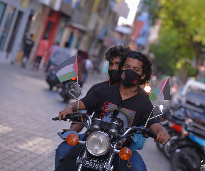 މެއި 19، 2021: ދިވެހީން ތިބީ ފަލަސްތީނާއެކުކަން ހާމަކުރުމުގެ ގޮތުން މުޅި މާލެތެރޭގައި ފަލަސްތީނުގެ ދިދަ: ދުނިޔޭގެ އެހެން ގައުމުތަކުން ފަލަސްތީނާއެކު ތިބިކަން ހާމަކޮށް އެއްވުންތައް ބޭއްވި ނަމަވެސް ކޮވިޑް ކާފިއުއާ ގުޅިގެން މާލޭގައި މިކަން ކުރީ އެމީހެއްގެ އަމިއްލަ ގޭގައި ތިބެގެން ފަލަސްތީނު ދިދަ ވިހުރުވައިގެން. އެހެން ނަމަވެސް މަދުމަދުން މަގުމައްޗަށް  ބައެއް މީހުން ނުކުމެ ޝުއޫރު ފާޅުކުރި --- ސަން ފޮޓޯ/ މުހައްމަދު މުޒައްޔިން ނާޒިމް