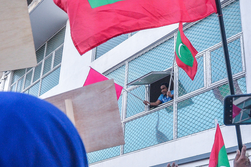 ސެޕްޓެމްބަރ 10، 2021: އިދިކޮޅު ކޯލިޝަނުން "އިންސާފު ހޯދަން" ނަމުގައި މާލޭގައި ބޭއްވި ހިންގާލުމުގެ ތެރެއިން، ކާނިވާ ސަރަހައްދުން ފުލުހުން ވަނީ ހިންގާލުމުގެ ބައިވެރިން ކުރިއަށް ނުދެވޭނެ ގޮތައް ބަންދުކޮށްފައި، މި އެއްވުމުގައި ކުރީގެ ރައީސް ޔާމީން އަބްދުލްގައްޔޫމް ވަނީ އިހުތިޖާޖުގެ ބައިވެރީން އެމަނިކުފާނަށް ދިން ޕީޕީއެމްގެ ދިދައަކާއި ގައުމީ ދިދައެއް ހިއްޕަވައިގެން ގޭގައި ހުންނަވާ އެއްވުމުގައި ބައިވެރިވެފަ -- ސަން ފޮޓޯ/ ފަޔާޒު މޫސާ