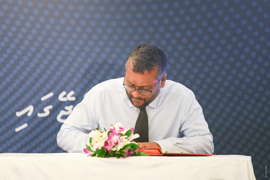 މިނިމަމް ވޭޖު ކަނޑައެޅުމުގެ އިގުރާރުގައި މިނިސްޓަރު ސޮއިކުރައްވަނީ -- ސަން ފޮޓޯ/ މުހައްމަދު ހައްޔާން